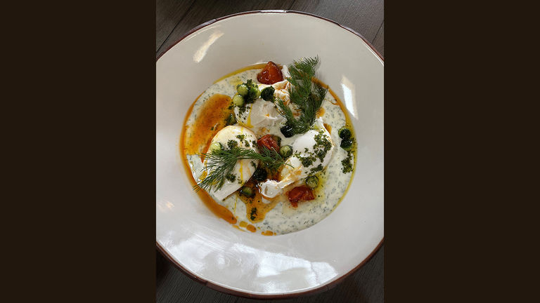 Preview dishes at Talia, which serves breakfast and dinner, included Turkish-style eggs in a yogurt dill sauce.