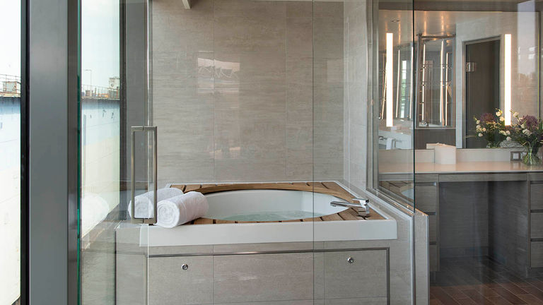 The Luxurious Owner’s Suite bathroom with whirlpool tub as seen from the glass-enclosed shower